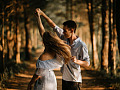 a couple dancing and twirling outside in nature